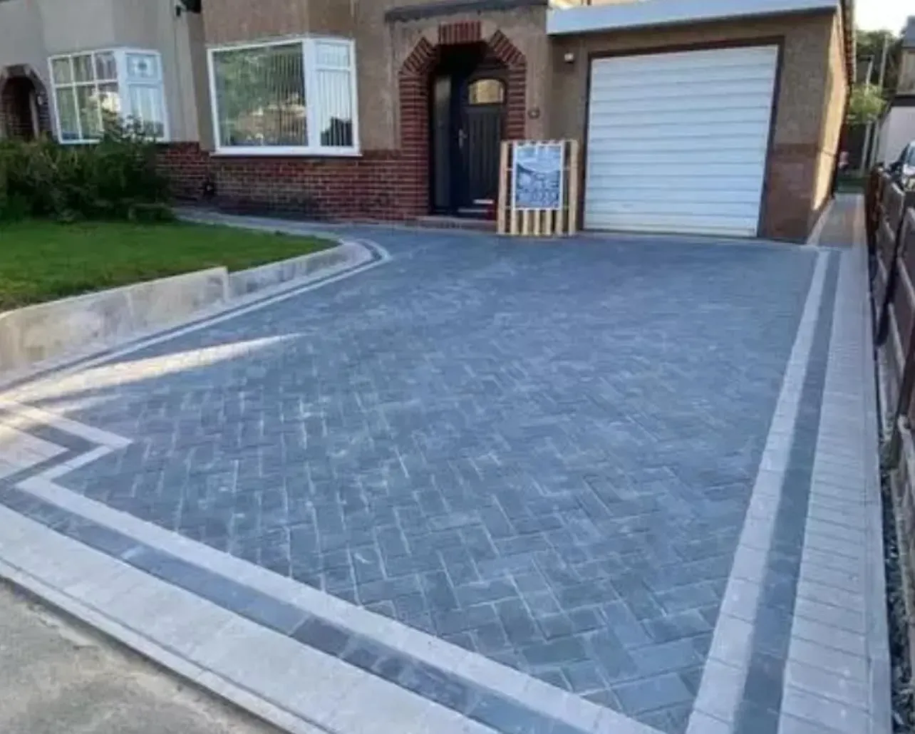 Charcoal herringbone block paving driveway with decorative border installation outside a residential home