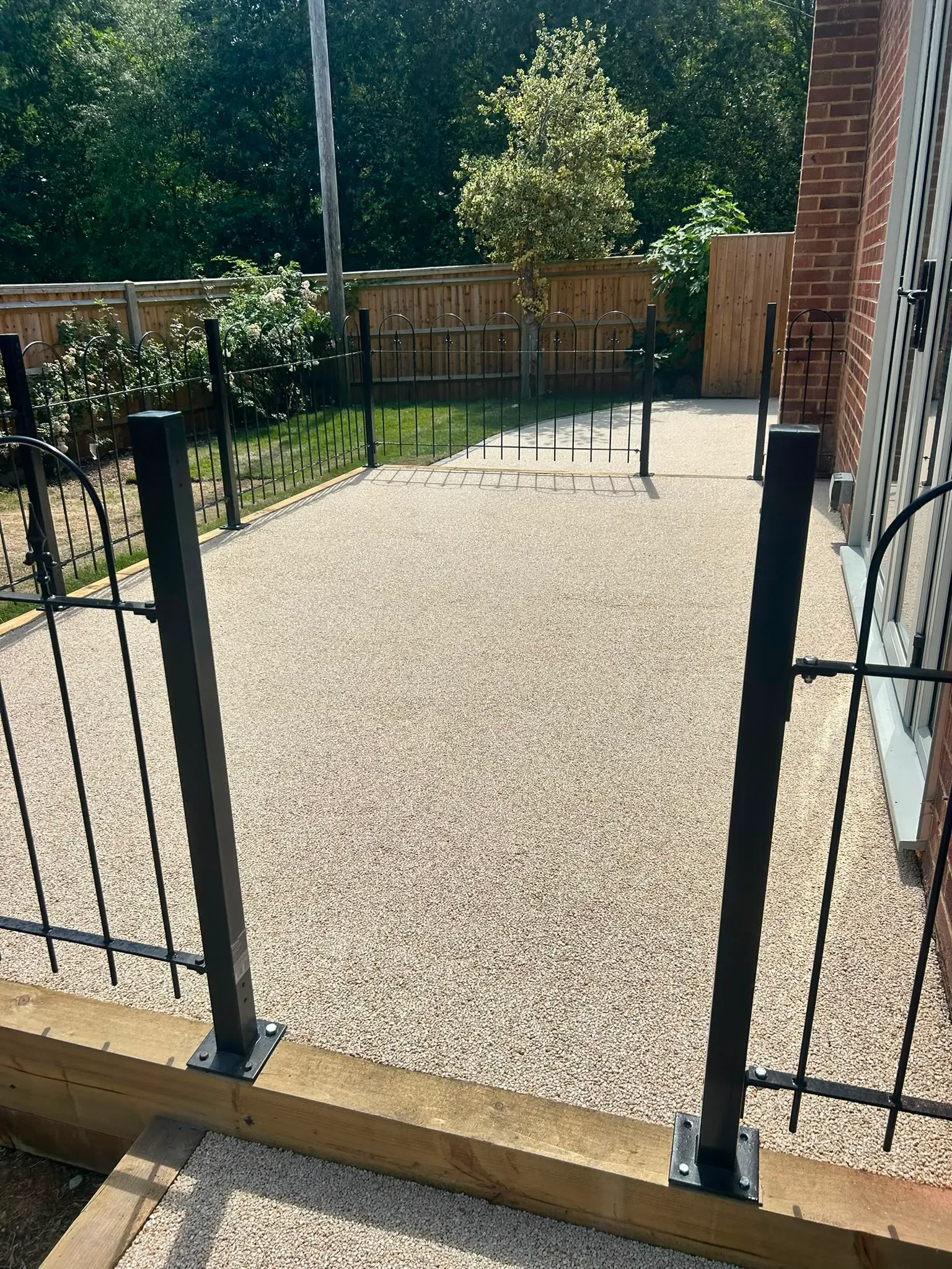 Permeable resin-bound patio and metal garden balustrade installed by River Vale (U.K) Ltd