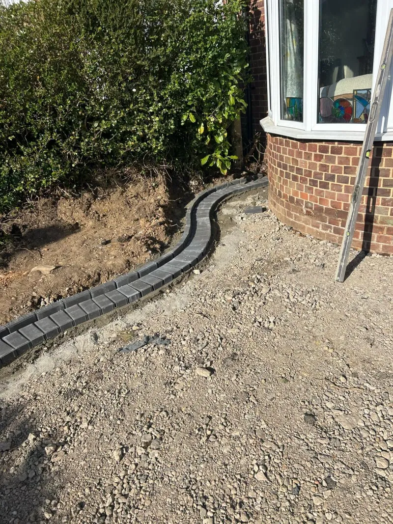 Curved border of block pavers and prepared sub-base for driveway
