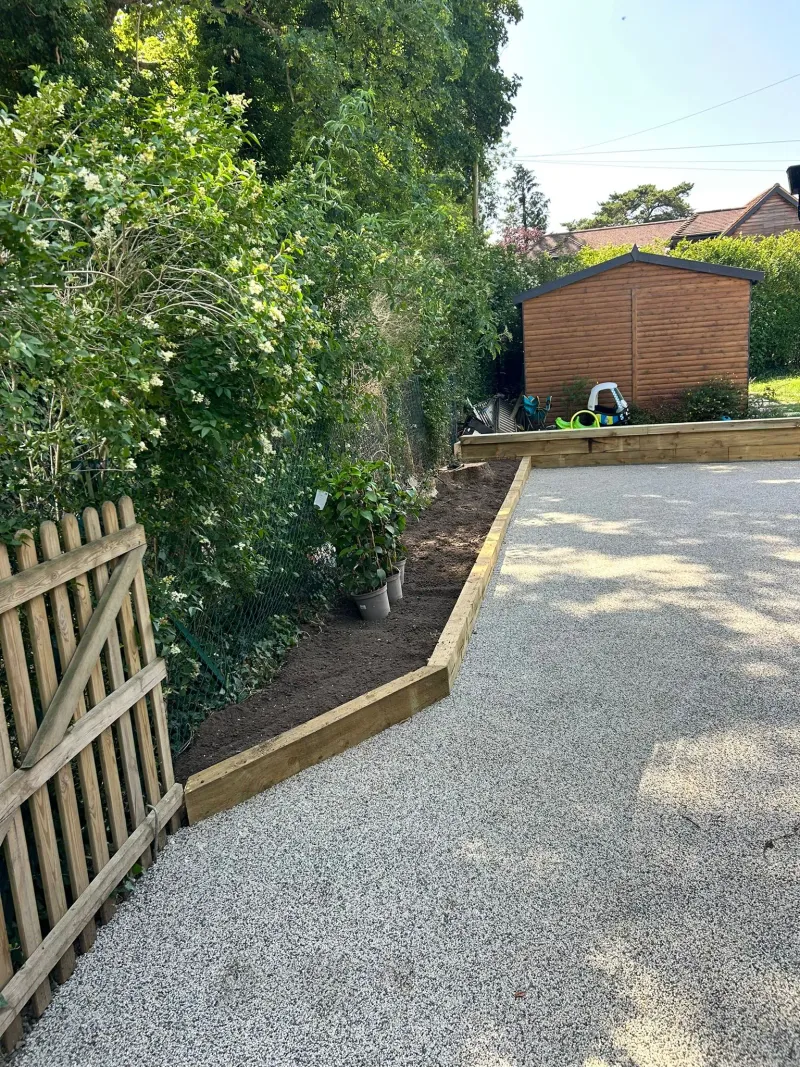 Permeable gravel driveway installation with timber sleeper edging
